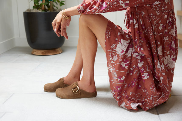 Woman wearing Vulture suede mules in chestnut with floral dress