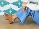 Woman wearing Woodpecker Shearling clogs in saddle with jeans and sweater