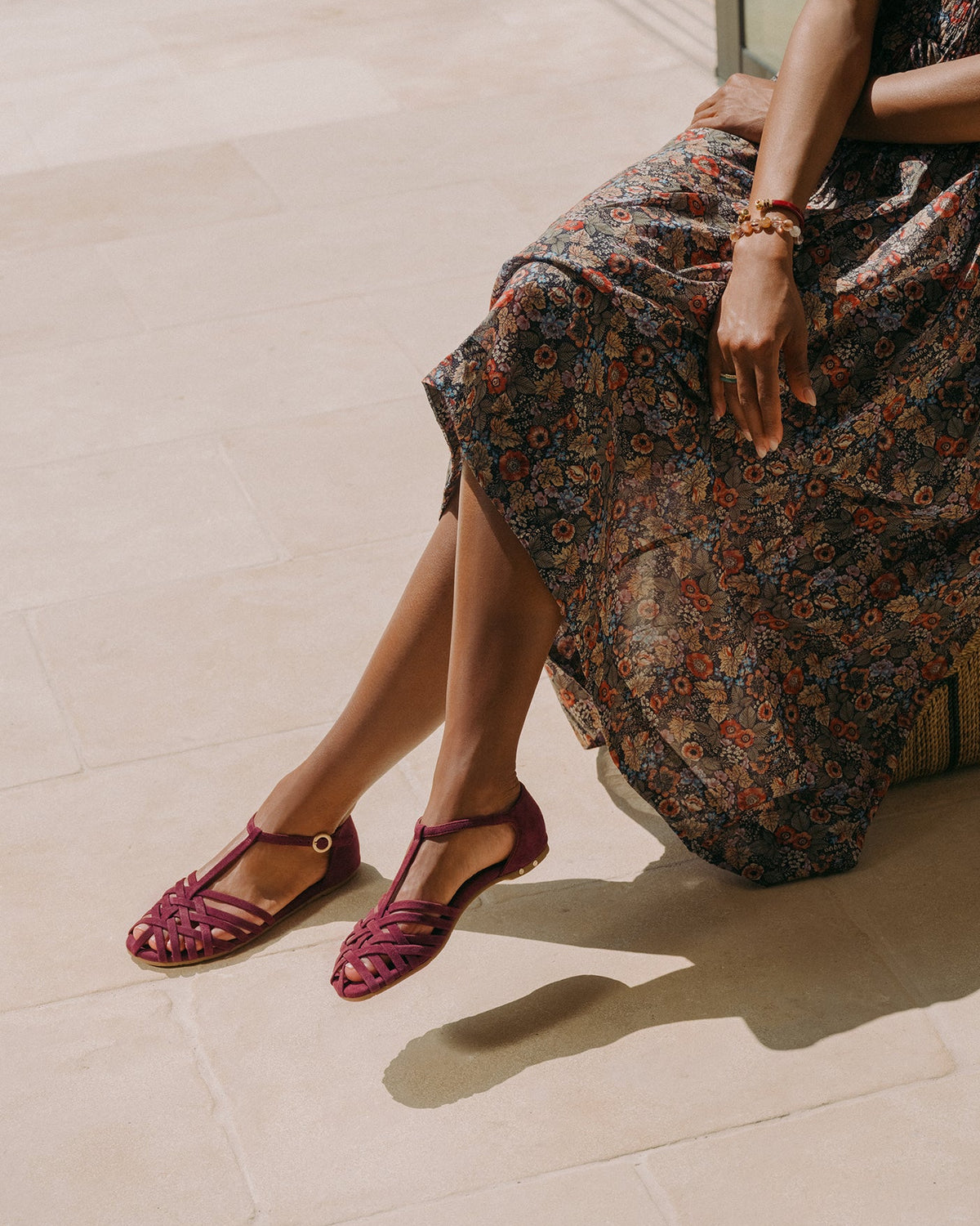 Woman wearing Wren suede basket woven ankle strap sandal in prune with floral dress