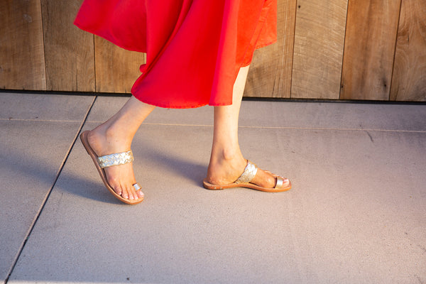 Woman wearing Cockatoo leather toe ring sandal in platinum/beach 