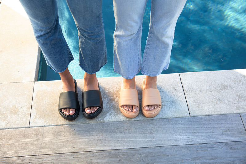 Women wearing Trumpeter leather platform sandal in black and beach